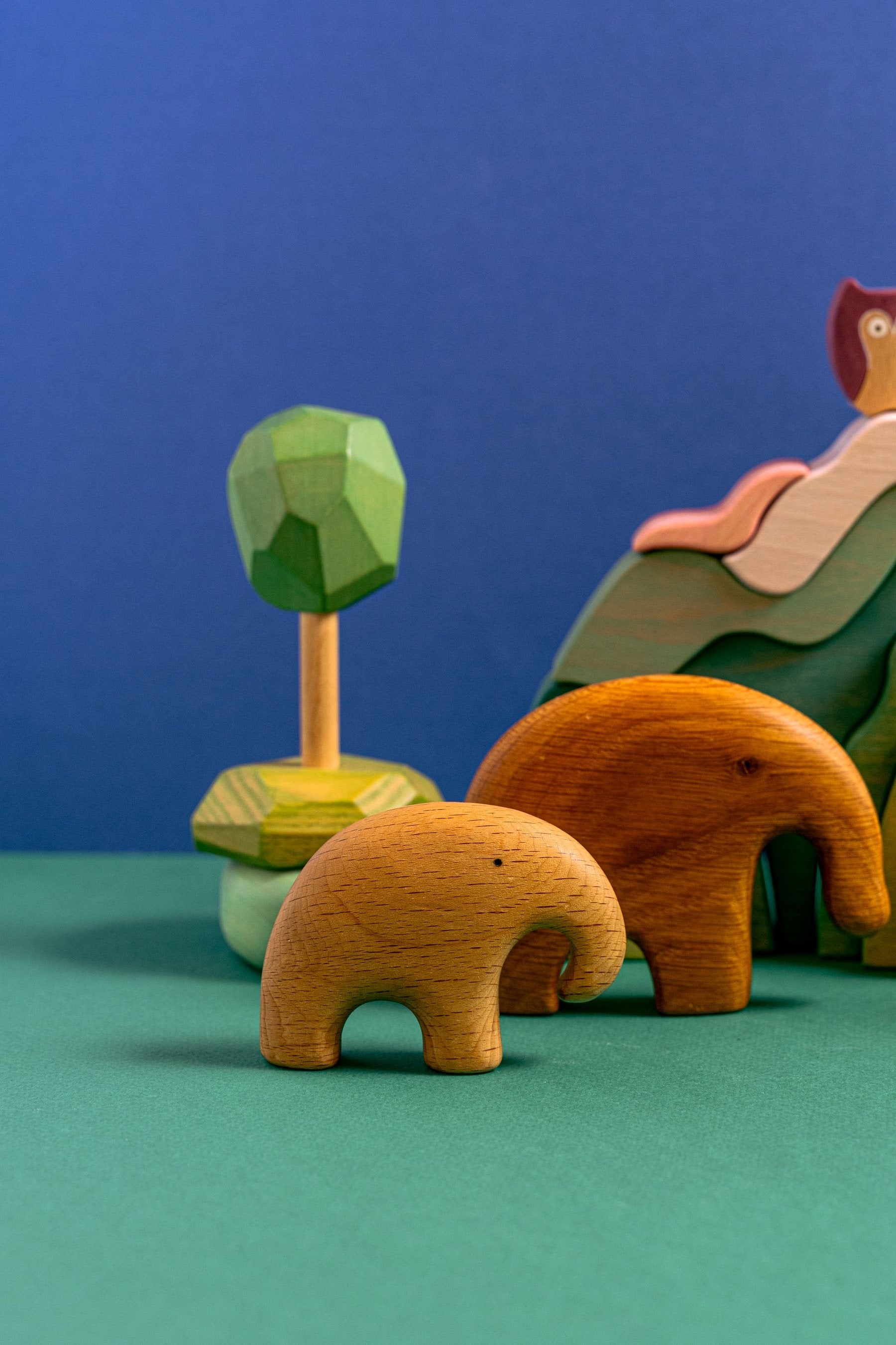 Colorful wooden animal toys on a green and blue backdrop