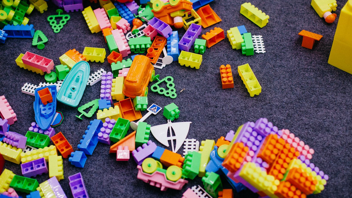 Colorful plastic building bricks scattered on a gray carpet