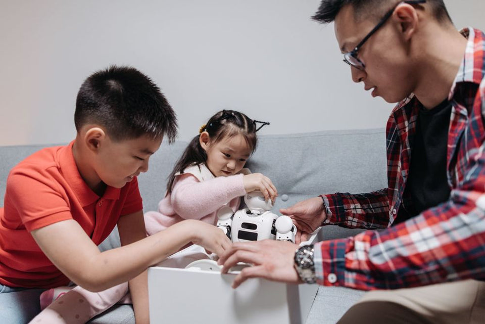 A parent and two children with a robot toy
